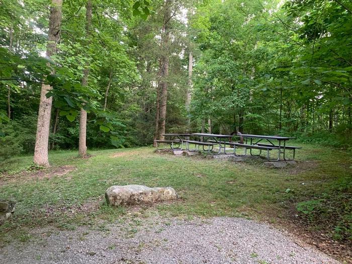 A gravel area with picnic tables.O-6 camping space.
