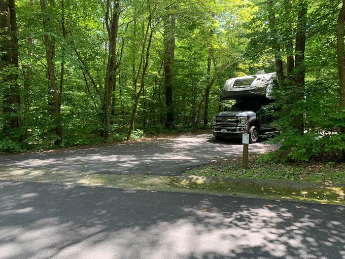 A blacktop area with a pickup camper on site.