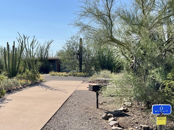 The driveway entrance into the campsite with a sign in front.