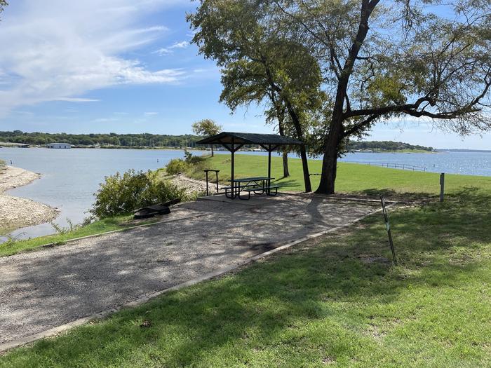 A photo of Site A22 of Loop A at CANEY CREEK with Picnic Table, Electricity Hookup, Fire Pit, Shade, Waterfront, Water Hookup