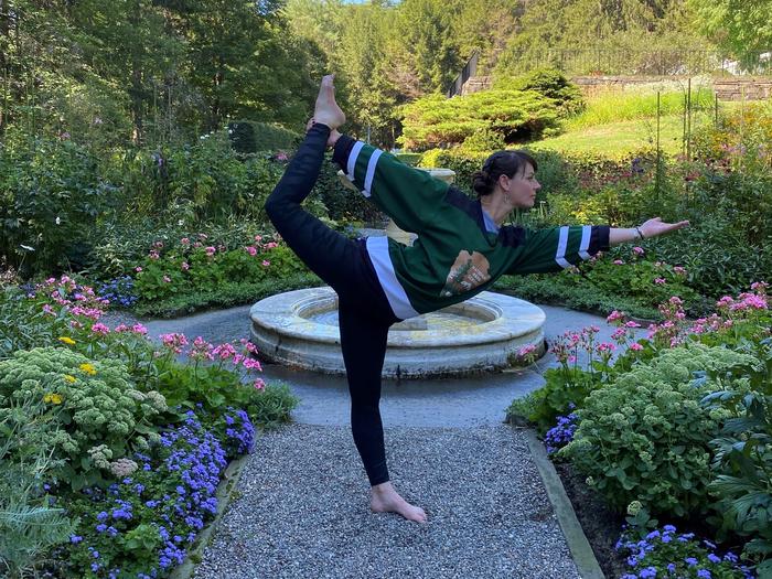 Person in arrowhead jersey does yoga post in formal gardenRanger Jen strikes a pose in the square garden behind historic mansion