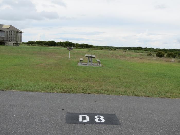 Pull through parking site, grass pad, picnic table, stand up grill, no shade, adjacent to comfort station restrooms, TENT ONLY