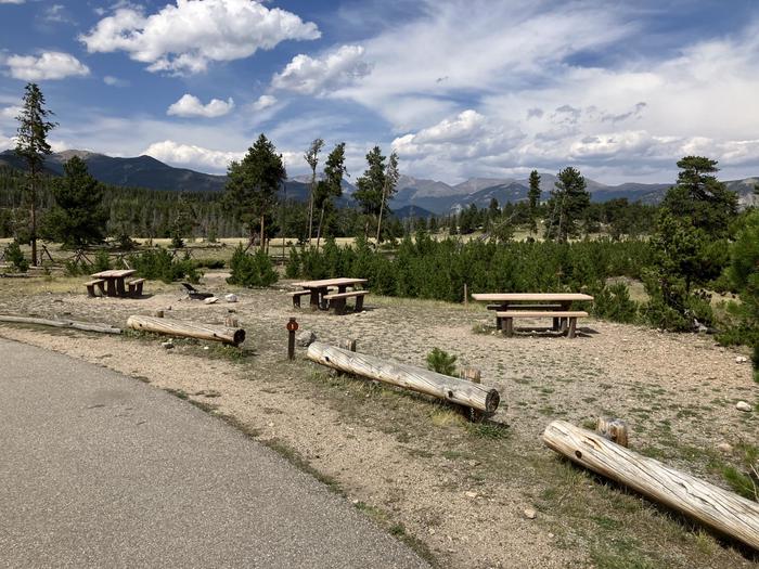 Group site with small pull-off divided by log barriers. Has 3 picnic tablesA small group site with multiple picnic tables and a well-marked parking area