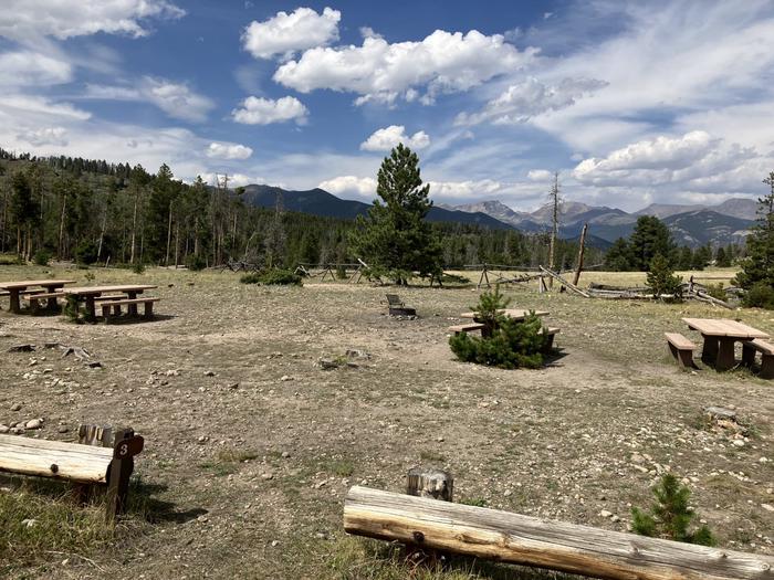 A wide-open site without many trees or ground cover. 4 picnic tables are in frame.A medium sized group site that can accommodate 16-25 people. Has 4 picnic tables and no shade. 