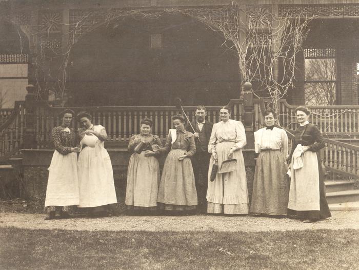 Black and white vintage photo of seven women and one man in servants uniformsBillings family servants posed in front of Mansion porch, 1886