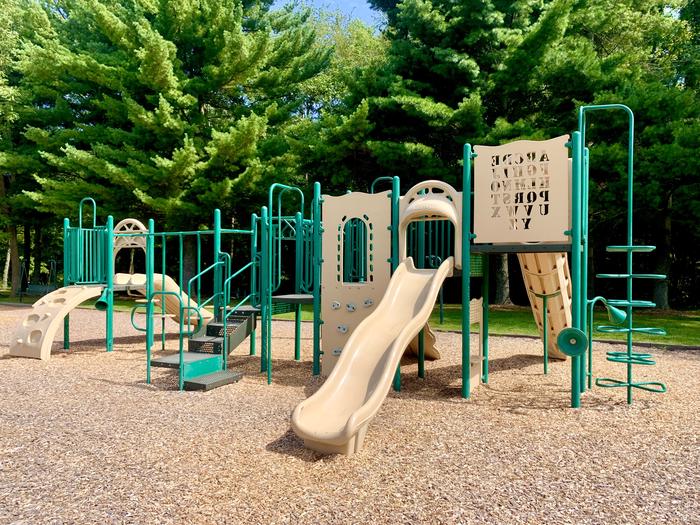 Tan slides and green playground equipment Playground next to Redbud Picnic Shelter