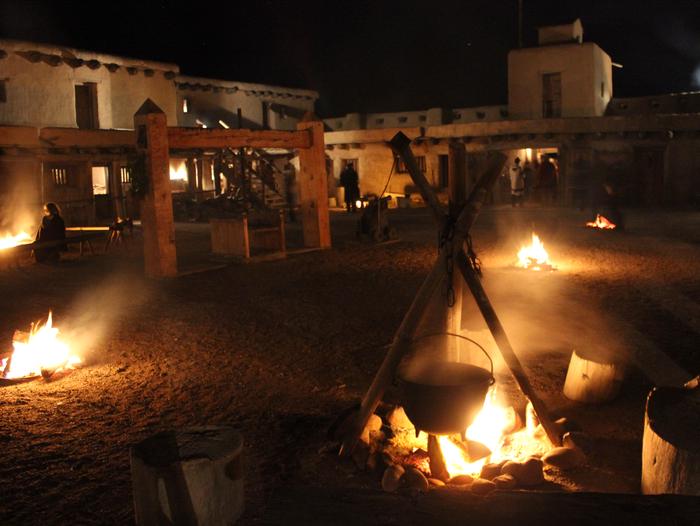 Plaza in Bent's Old Fort at night with fires lit