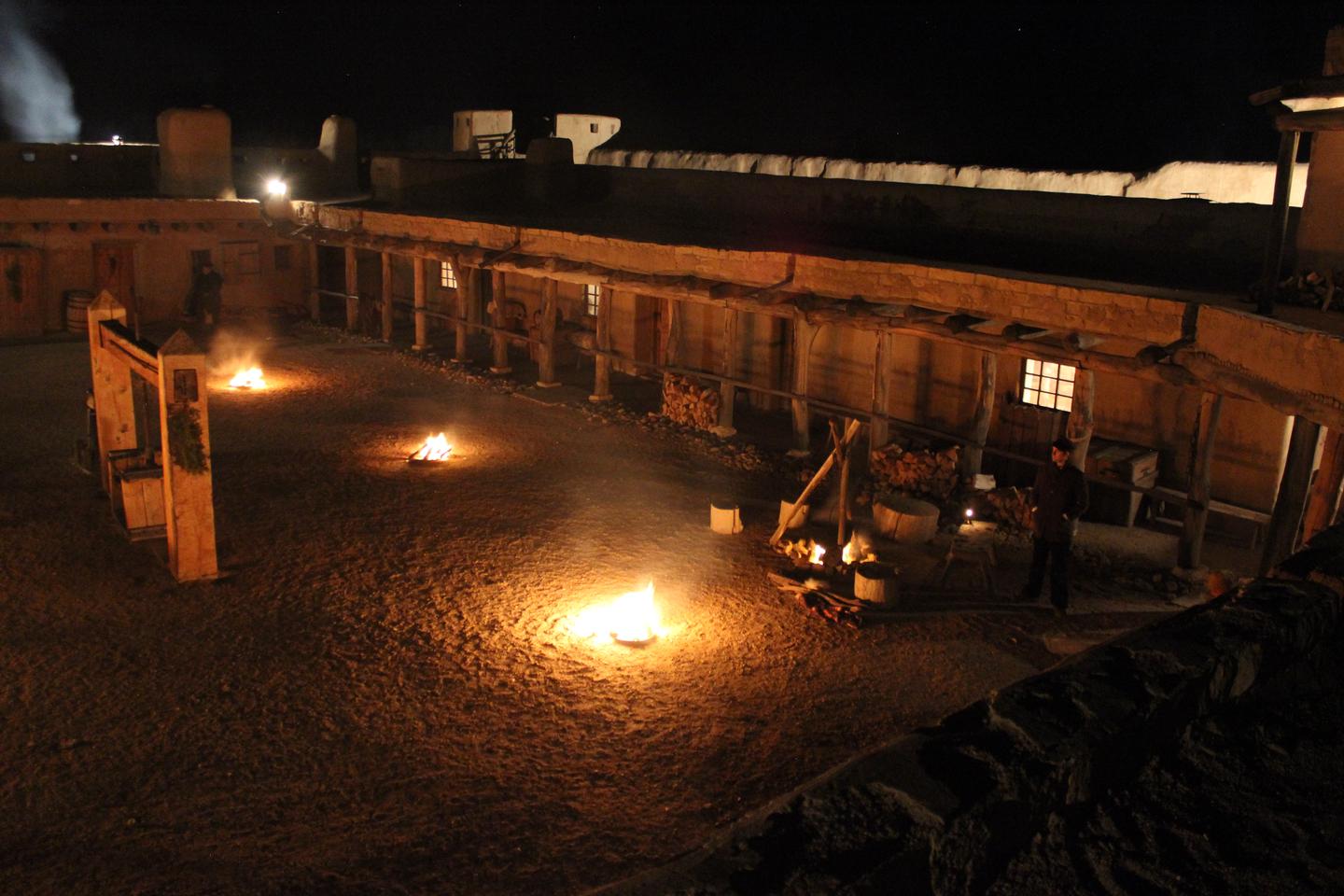 The plaza of Bent's Old Fort at night lit with fires