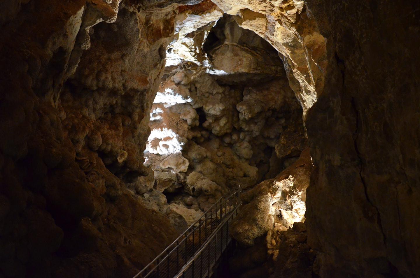 A large cave room with an elevated pathwayCalcite crystal completely coats Jewel Cave where breakdown did not occur.