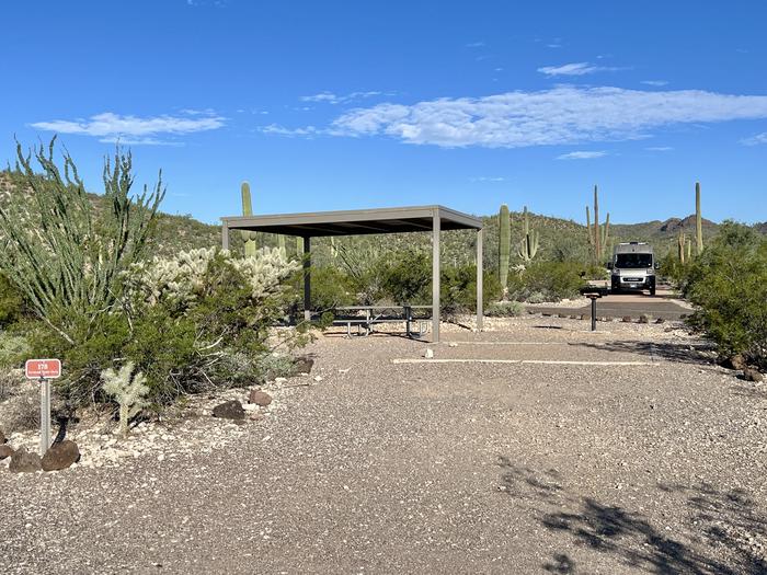 The large square tent pad of the site with the picnic table and grill.Each site has tent pad, picnic table and grill and is surrounded by cacti and other desert plants.