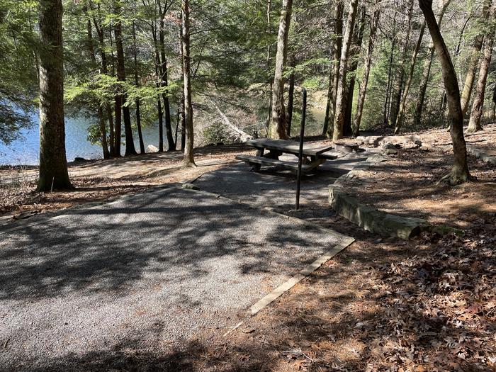 A photo of site 16 of Lower Loop at Lake Conasauga Campground with picnic table, fire pit, shade, tent pad, waterfront, and lantern pole.A phot of site 16 of Lower Loop at Lake Conasauga Campground with picnic table, fire pit, shade, tent pad, waterfront, and lantern pole.