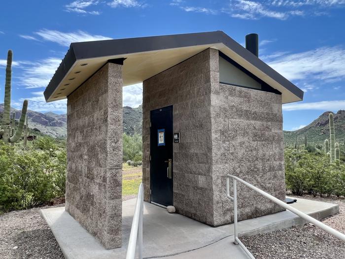 The restroom, a one stall vault toilet building with a ADA ramp.The vault toilet restroom is ADA accessible.