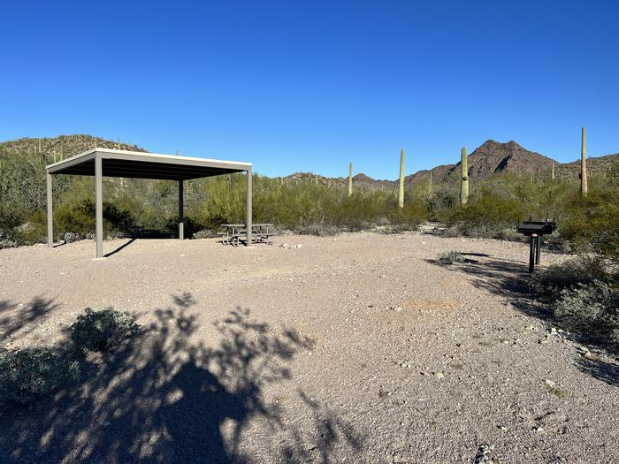 The picnic table and grill with a mountain in the background.Each site has plenty of space to pitch tents.