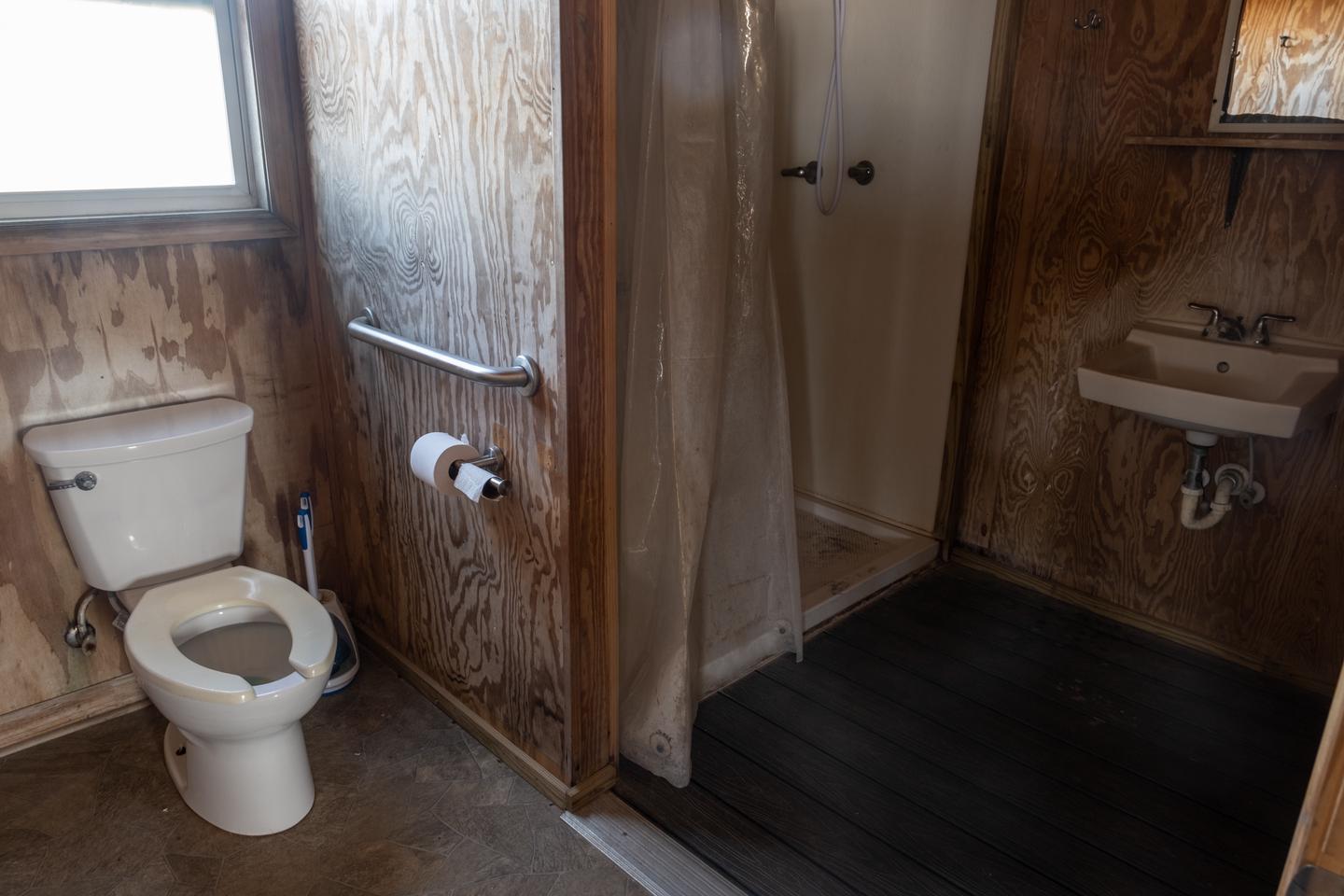 View of the accessible bathroom, showing toilet, shower, and sink.Accessible bathroom.