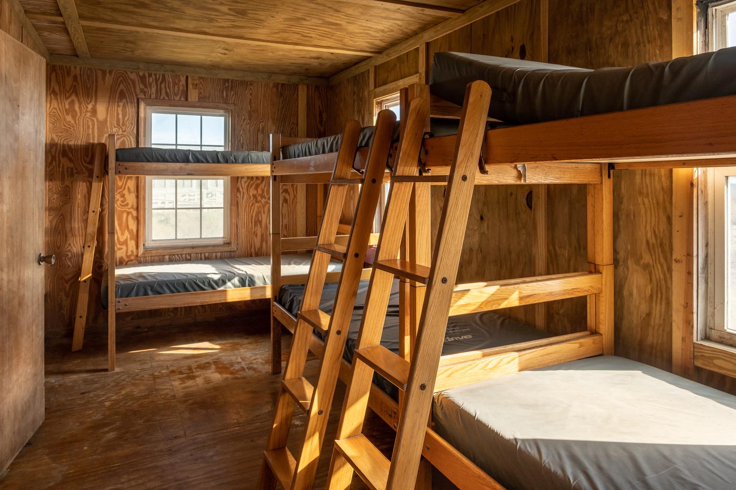 Bedroom with 3 bunk beds along the walls.Bedroom area.