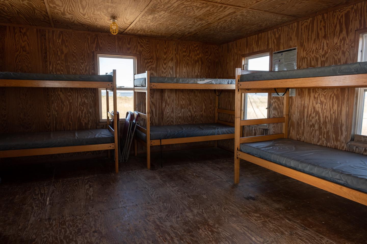 A view of the living room / bedroom area showing 3 bunk beds.Living room/bedroom with 3 bunk beds.