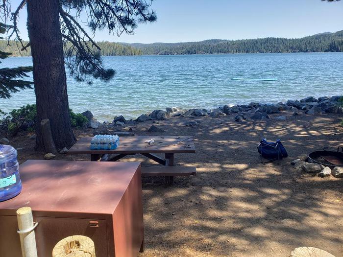 Beautiful waterfront site featuring a picnic table, fire ring, and bear box.Sundew Site 4