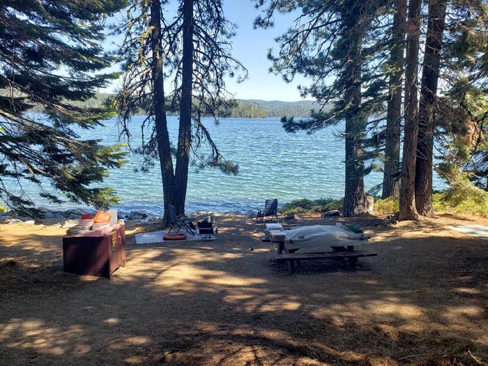 Beautiful waterfront site featuring a picnic table, fire ring, and bear box.Sundew Site 8