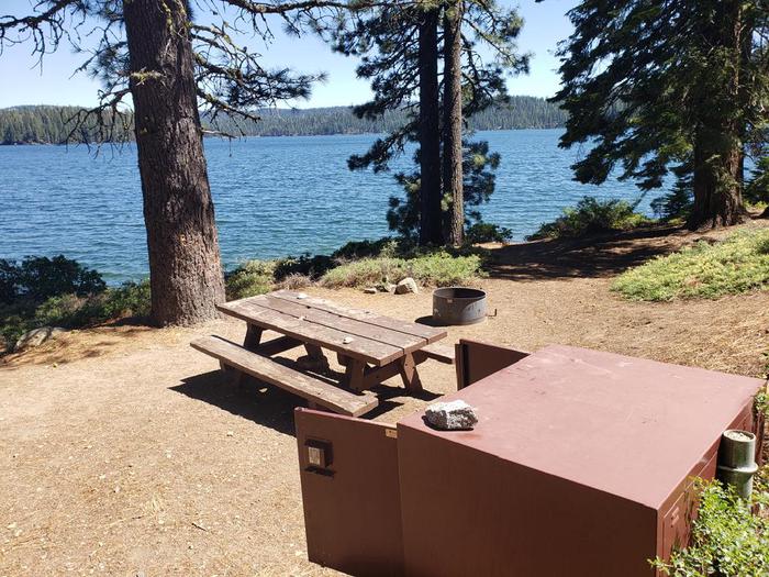 Beautiful waterfront site featuring a picnic table, fire ring, and bear box.Sundew Site 9