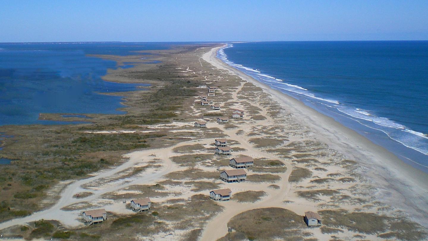 An aerial view of Great Island Cabin Camp, with the ocean on the right, the sound on the left, and the cabin area in the centerAn aerial view of Great Island Cabin Camp.
