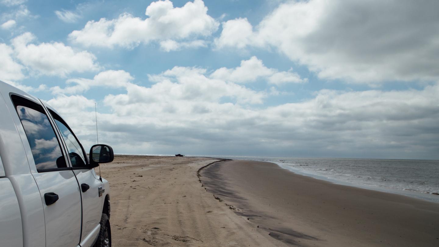 White truck driving down the OSV zone.Enjoy the miles of unspoiled beaches in the OSV zone.