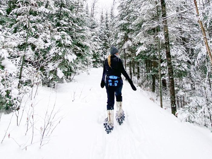 A woman snowshoes on a winter trail in Voyageurs National Park