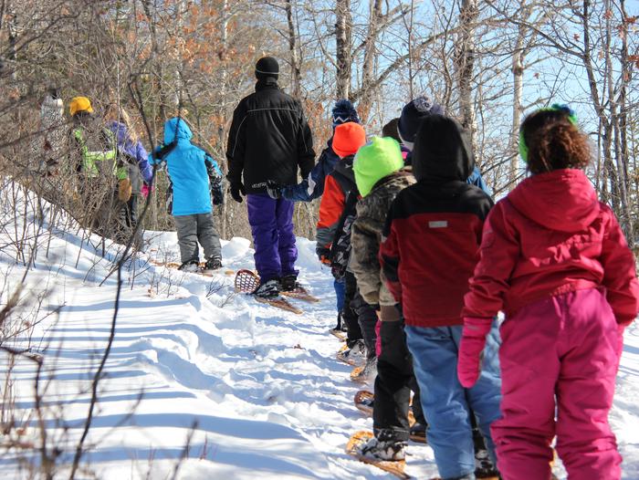 A group of students snowshoe along a trail in Voyageurs National Park