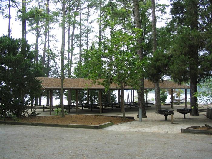 Multiple picnic tables and 2 grills located next to beach and playgroundBeach Shelter