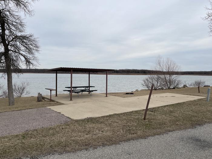 A photo of Site E15 of Loop E at LAKESIDE (OK) with Picnic Table, Electricity Hookup, Fire Pit, Shade, Waterfront, Water Hookup