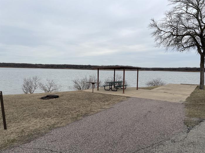 A photo of Site E22 of Loop E at LAKESIDE (OK) with Picnic Table, Electricity Hookup, Fire Pit, Shade, Waterfront, Water Hookup