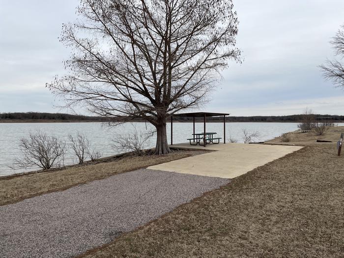 A photo of Site E19 of Loop E at LAKESIDE (OK) with Picnic Table, Electricity Hookup, Fire Pit, Shade, Waterfront, Water Hookup