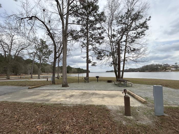A photo of Site 020 of Loop MPOI at WHITE OAK (CREEK) CAMPGROUND with Picnic Table, Electricity Hookup, Fire Pit, Shade, Waterfront, Lantern Pole, Water Hookup