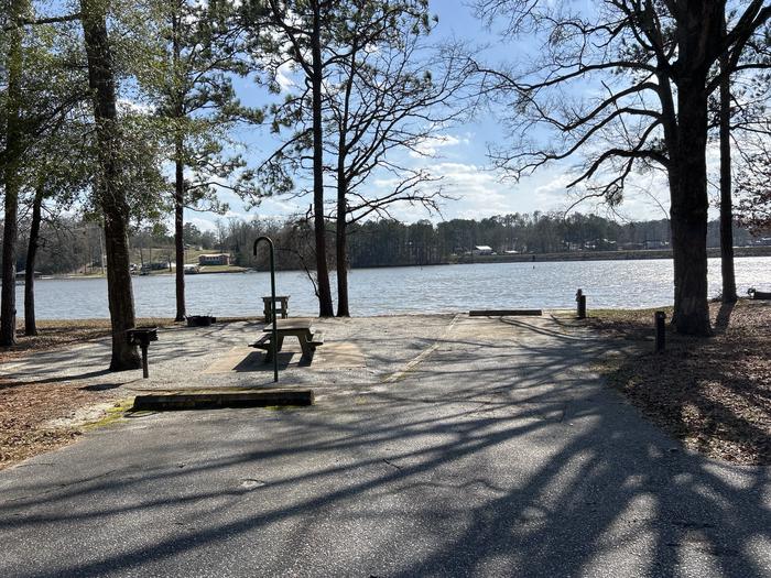 A photo of Site 006 of Loop MPOI at WHITE OAK (CREEK) CAMPGROUND with Picnic Table, Electricity Hookup, Fire Pit, Shade, Waterfront, Lantern Pole, Water Hookup