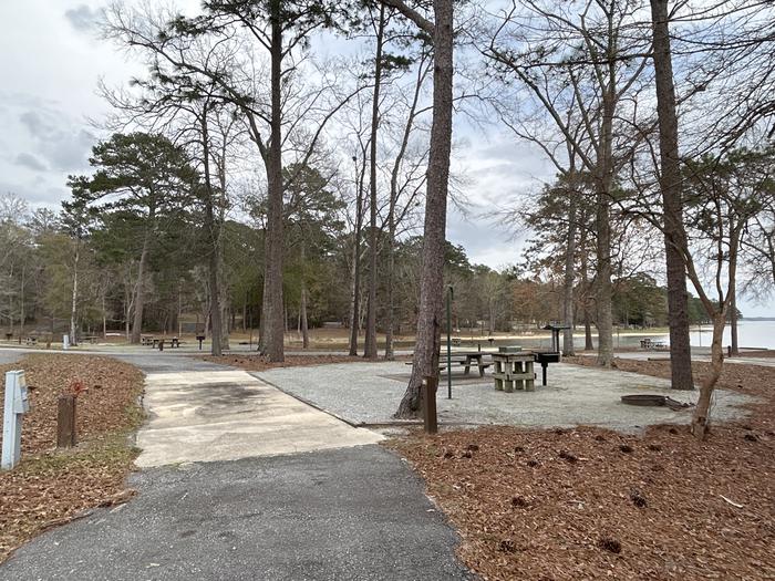A photo of Site 025 of Loop MPOI at WHITE OAK (CREEK) CAMPGROUND with Picnic Table, Electricity Hookup, Fire Pit, Shade, Waterfront, Lantern Pole, Water Hookup