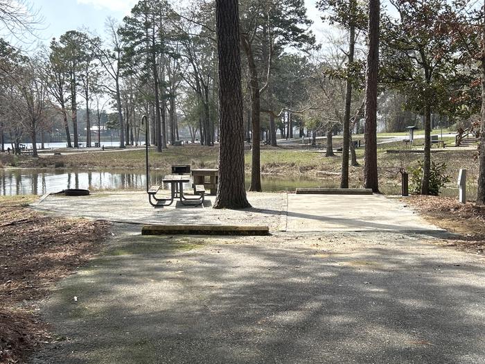 A photo of Site 032 of Loop OAKW at WHITE OAK (CREEK) CAMPGROUND with Picnic Table, Electricity Hookup, Fire Pit, Shade, Waterfront, Lantern Pole, Water Hookup