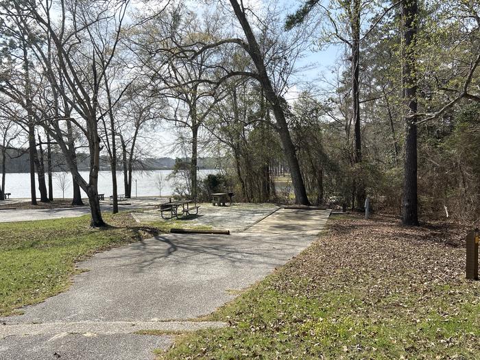 A photo of Site 053 of Loop OAKW at WHITE OAK (CREEK) CAMPGROUND with Picnic Table, Electricity Hookup, Fire Pit, Shade, Waterfront, Lantern Pole, Water Hookup