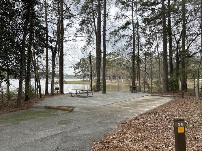 A photo of Site 036 of Loop OAKW at WHITE OAK (CREEK) CAMPGROUND with Picnic Table, Electricity Hookup, Fire Pit, Shade, Waterfront, Lantern Pole, Water Hookup