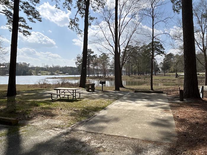 A photo of Site 033 of Loop OAKW at WHITE OAK (CREEK) CAMPGROUND with Picnic Table, Electricity Hookup, Fire Pit, Shade, Waterfront, Lantern Pole, Water Hookup