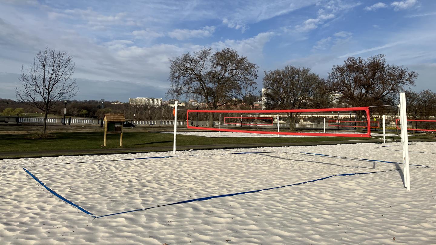 Parkway Drive Volleyball Courts with the Potomac River in the background and a small bulletin board close by.