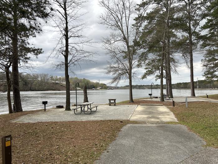 A photo of Site 074 of Loop CVIE at WHITE OAK (CREEK) CAMPGROUND with Picnic Table, Electricity Hookup, Fire Pit, Shade, Waterfront, Lantern Pole, Water Hookup