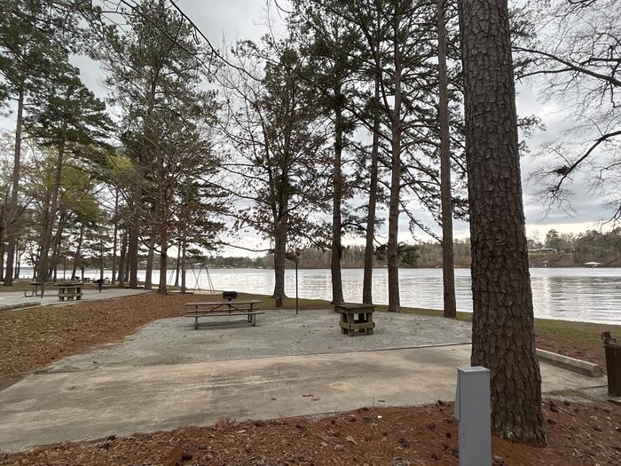 A photo of Site 069 of Loop CVIE at WHITE OAK (CREEK) CAMPGROUND with Picnic Table, Electricity Hookup, Fire Pit, Shade, Waterfront, Lantern Pole, Water Hookup