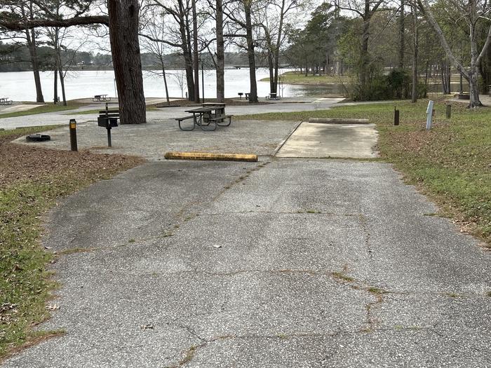 A photo of Site 054 of Loop OAKW at WHITE OAK (CREEK) CAMPGROUND with Picnic Table, Electricity Hookup, Fire Pit, Shade, Waterfront, Lantern Pole, Water Hookup