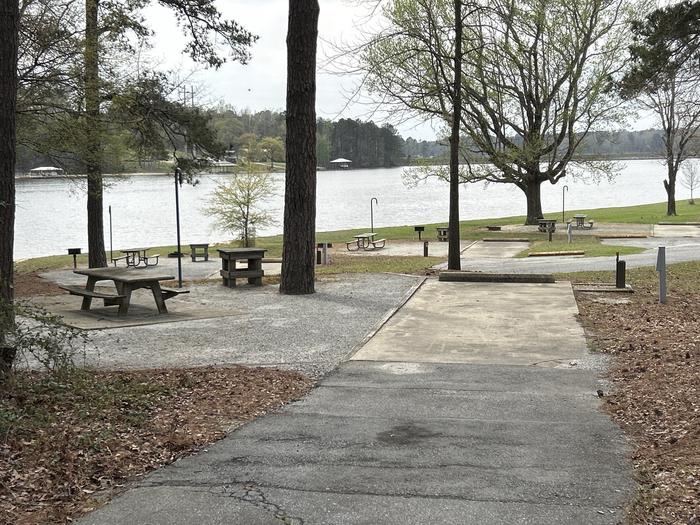 A photo of Site 059 of Loop OAKW at WHITE OAK (CREEK) CAMPGROUND with Picnic Table, Electricity Hookup, Fire Pit, Shade, Waterfront, Lantern Pole, Water Hookup