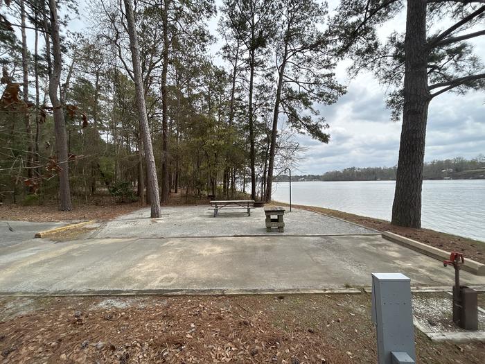 A photo of Site 051 of Loop OAKW at WHITE OAK (CREEK) CAMPGROUND with Picnic Table, Electricity Hookup, Fire Pit, Shade, Waterfront, Lantern Pole, Water Hookup