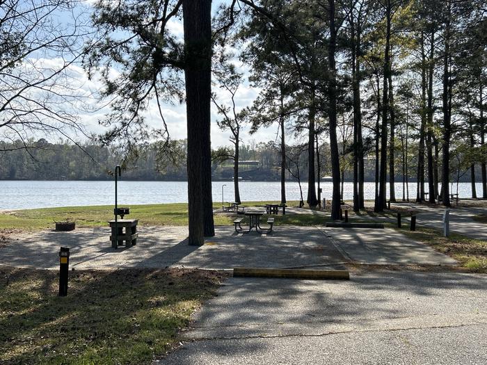 A photo of Site 085 of Loop CVIE at WHITE OAK (CREEK) CAMPGROUND with Picnic Table, Electricity Hookup, Fire Pit, Shade, Waterfront, Lantern Pole, Water Hookup