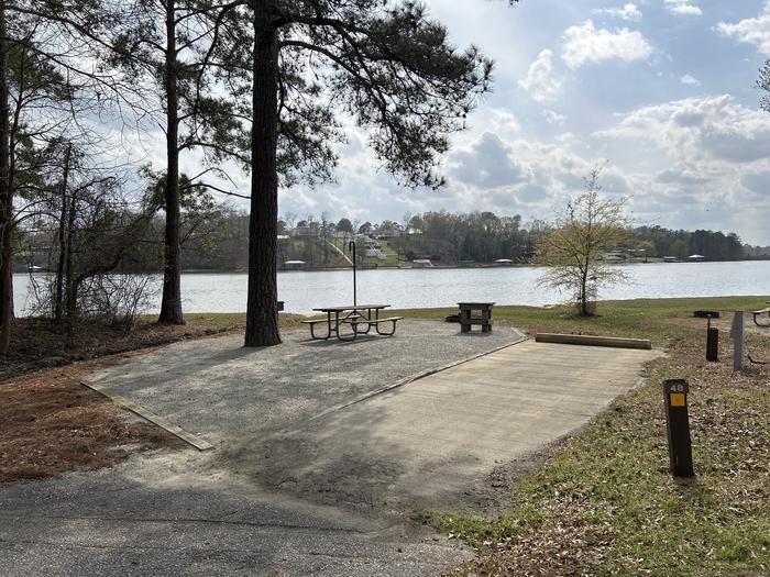 A photo of Site 048 of Loop OAKW at WHITE OAK (CREEK) CAMPGROUND with Picnic Table, Electricity Hookup, Fire Pit, Shade, Waterfront, Lantern Pole, Water Hookup