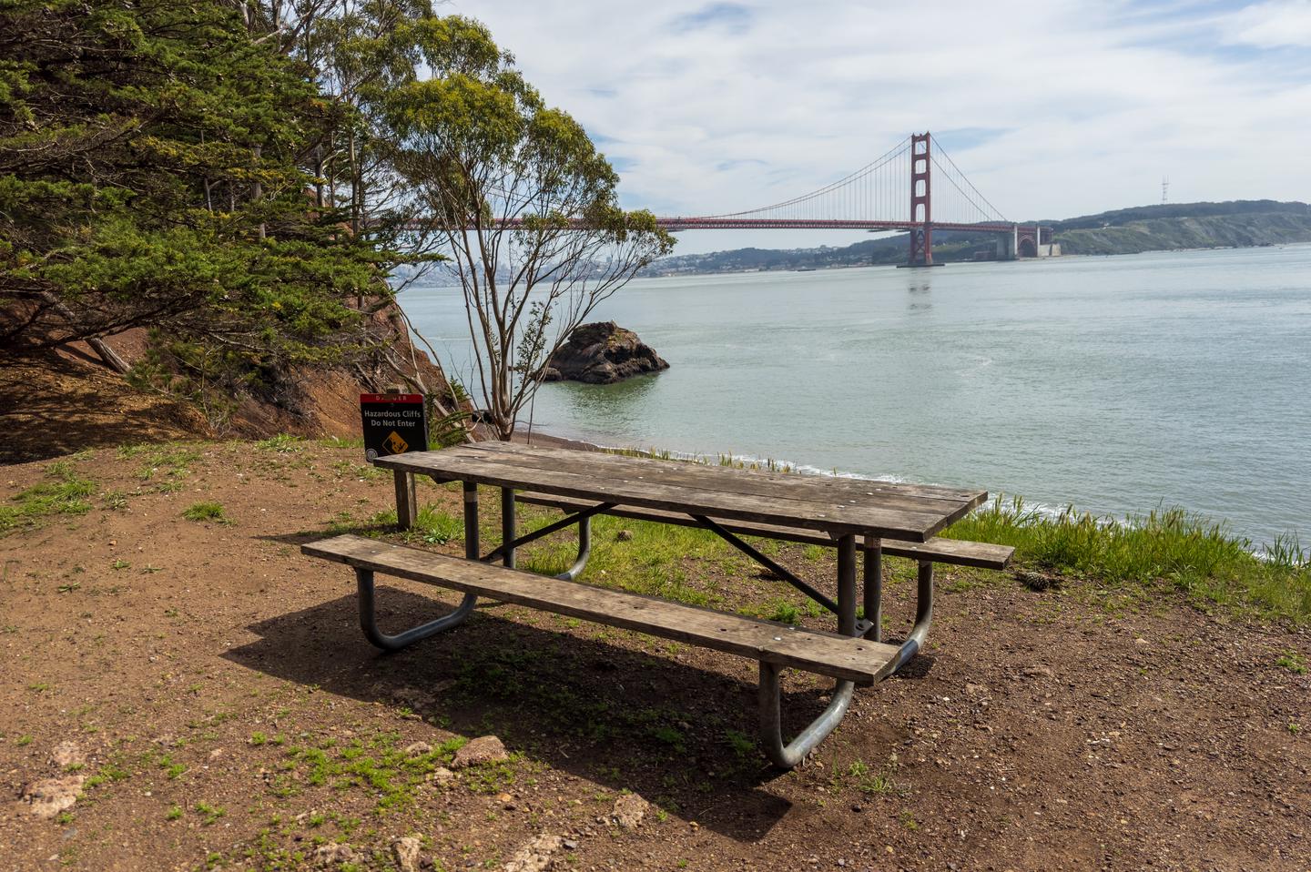 Picnic table at the cliff's edge of Site 1. In background is the bay waters and the Golden Gate Bridge.View of the Golden Gate Bridge from Site 1.