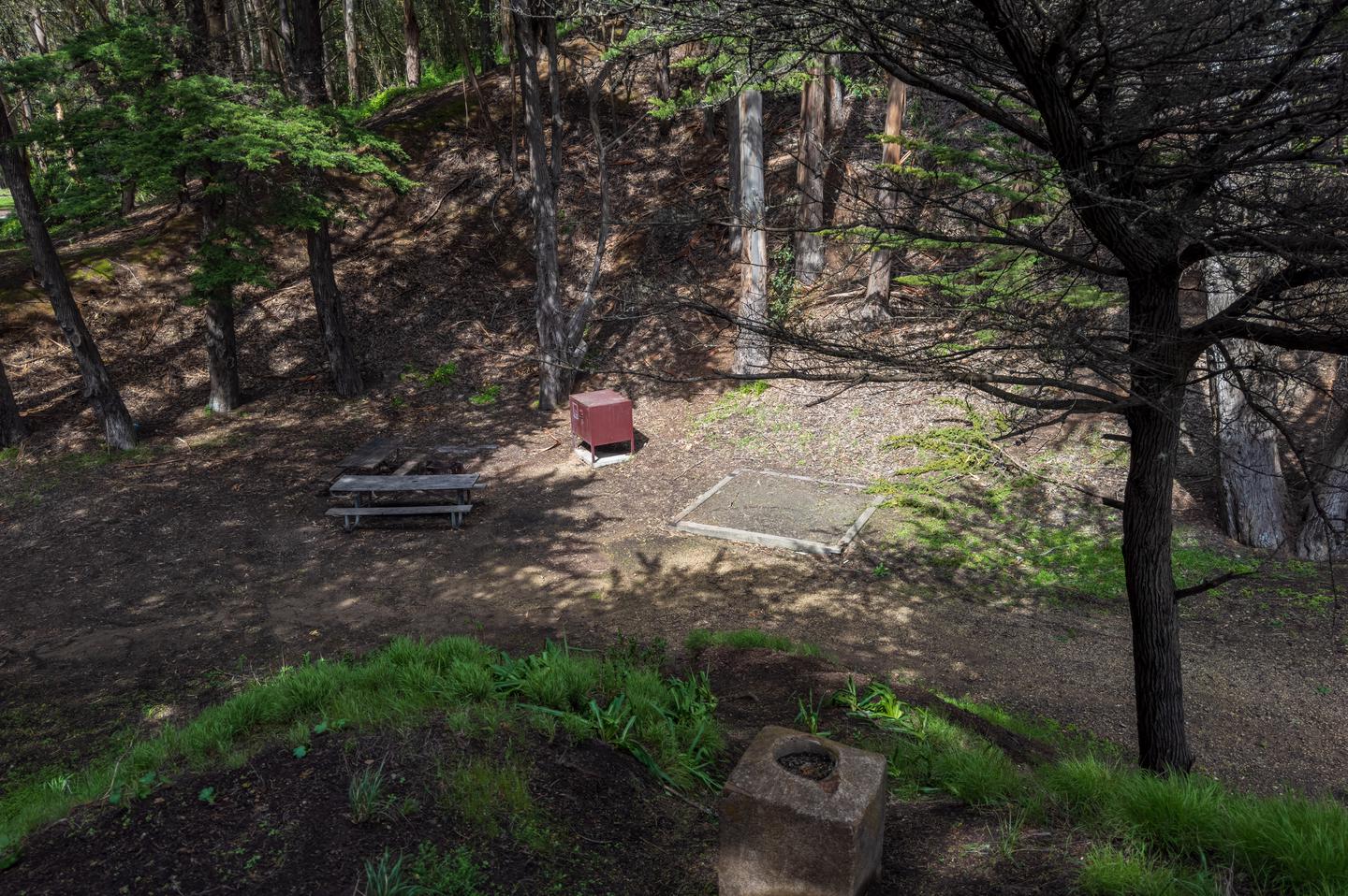 High view looking down at the Site 1 picnic tables, bear locker, and fire pit. To the right is the first of 3 tent pads at this site.High view of Site 1.