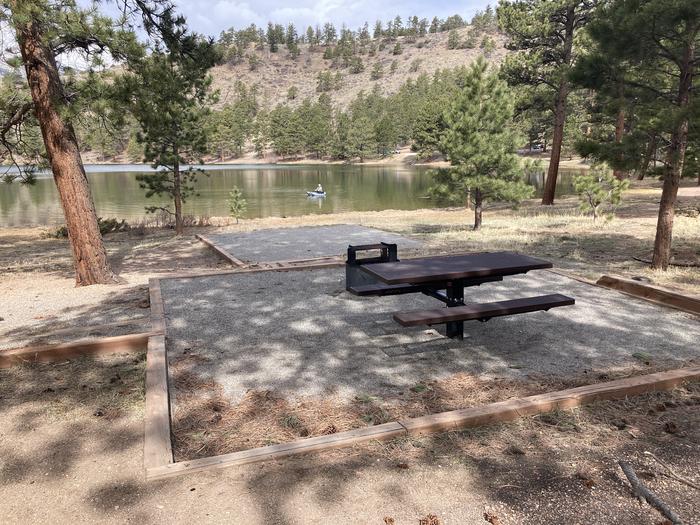 Campsite in the trees with picnic table and fire pit, lake in backgroundA photo of Site 020 with Picnic Table, Fire Pit