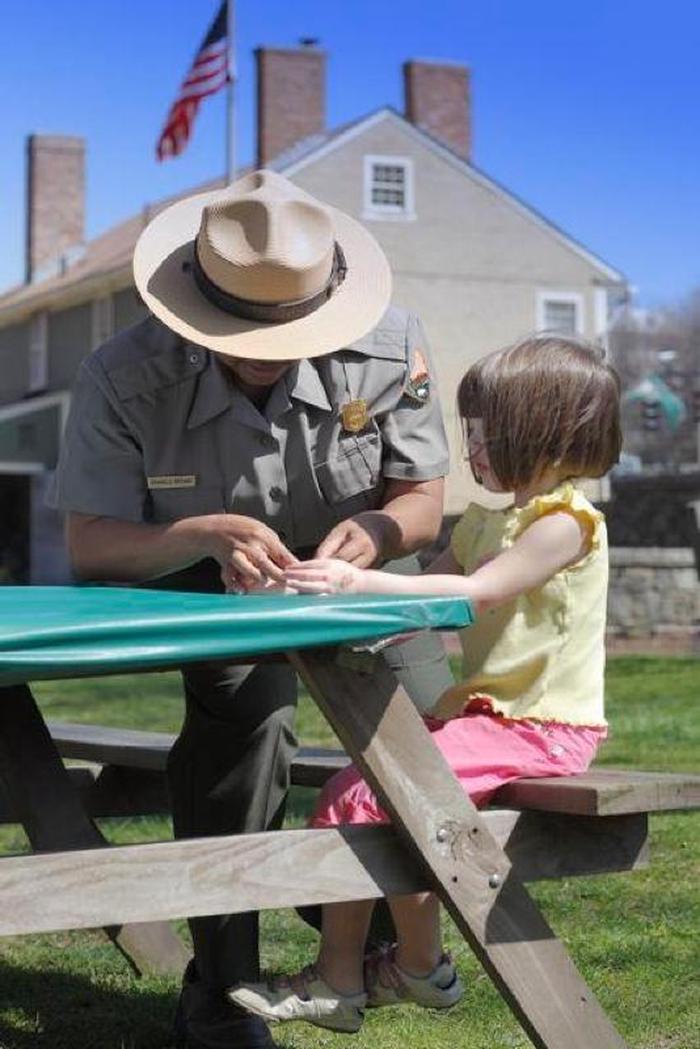 Ranger helping a child with an activity